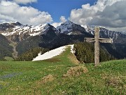 90 E scopro bella rustica croce lignea sui verdi prati fioriti con vista panoramica verso Monte Cavallo e amici 
